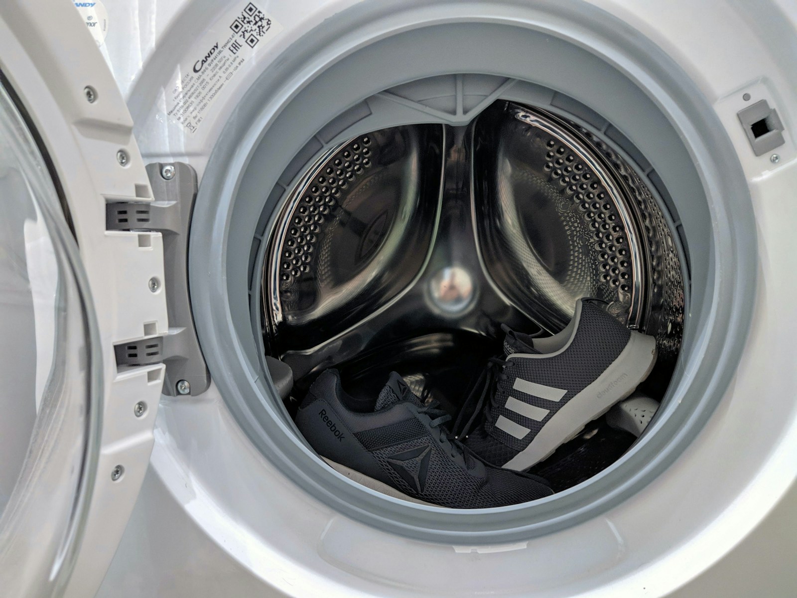 Open front-load washing machine drum with laundry inside