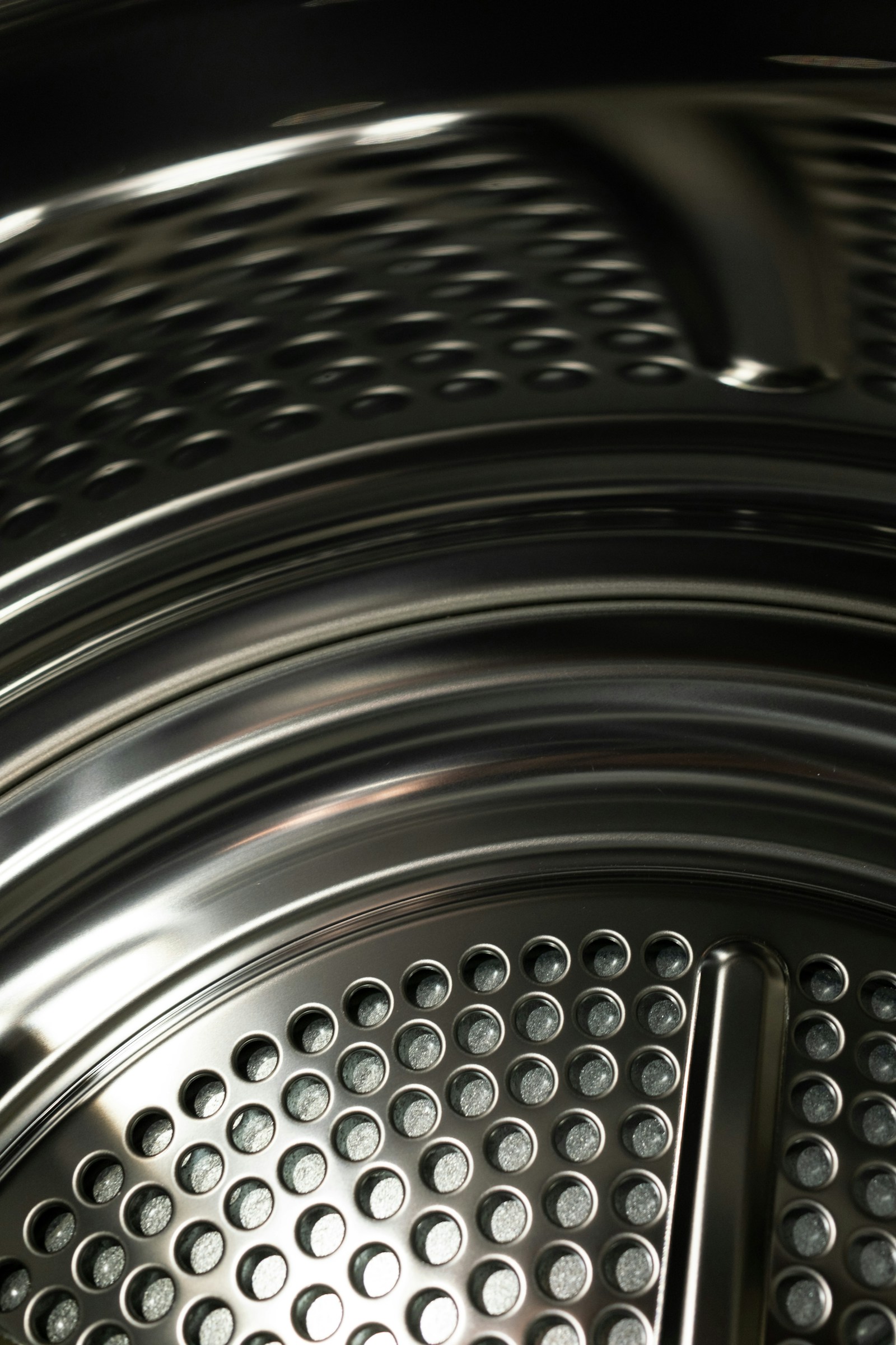 Close-up view inside a washing machine drum showing the stainless-steel paddles