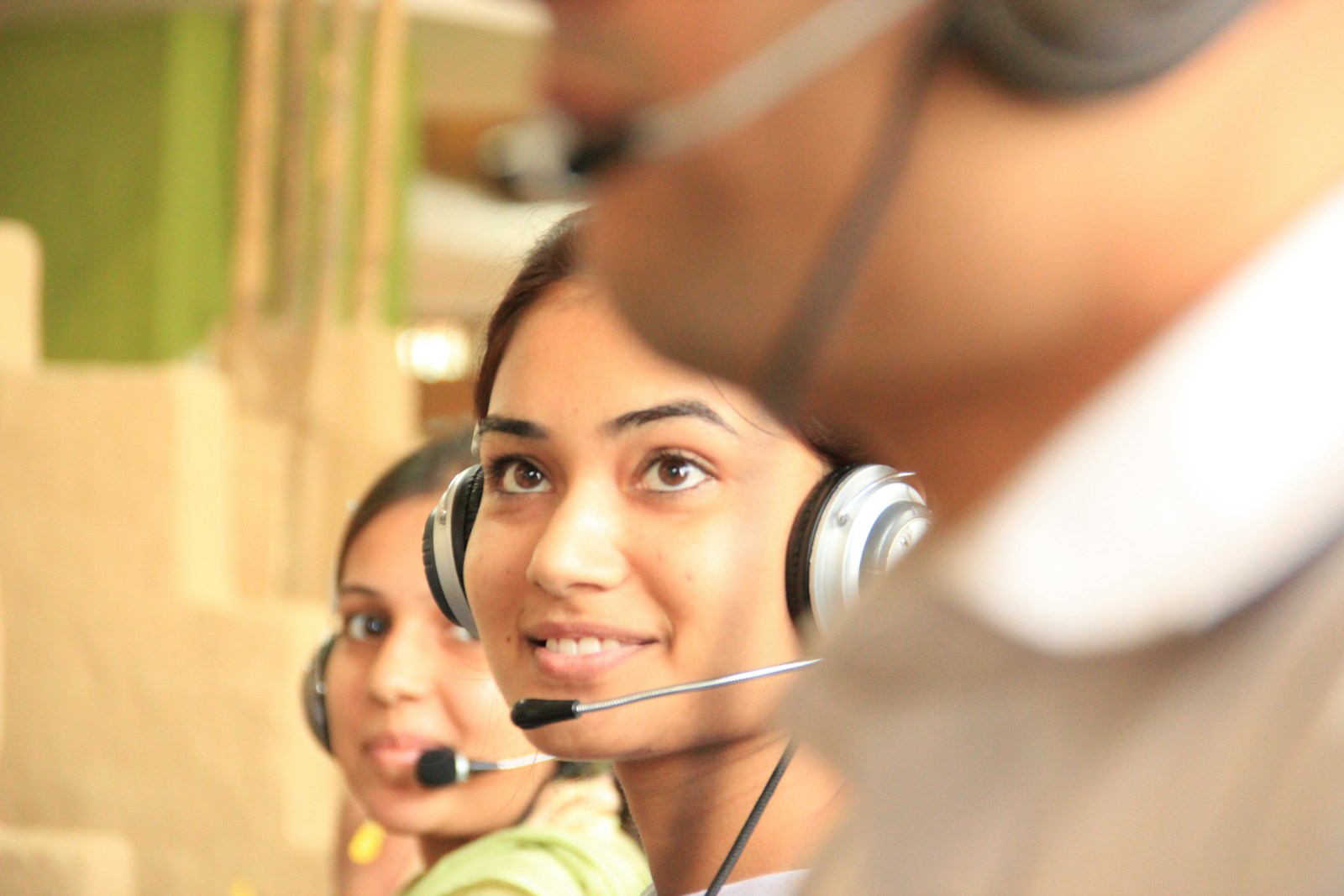 Customer support team members wearing headsets in a bright office