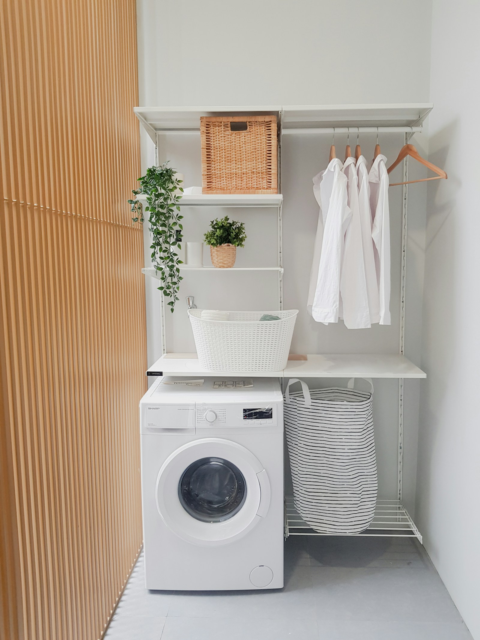 Home laundry room with a washer and dryer and wall shelving
