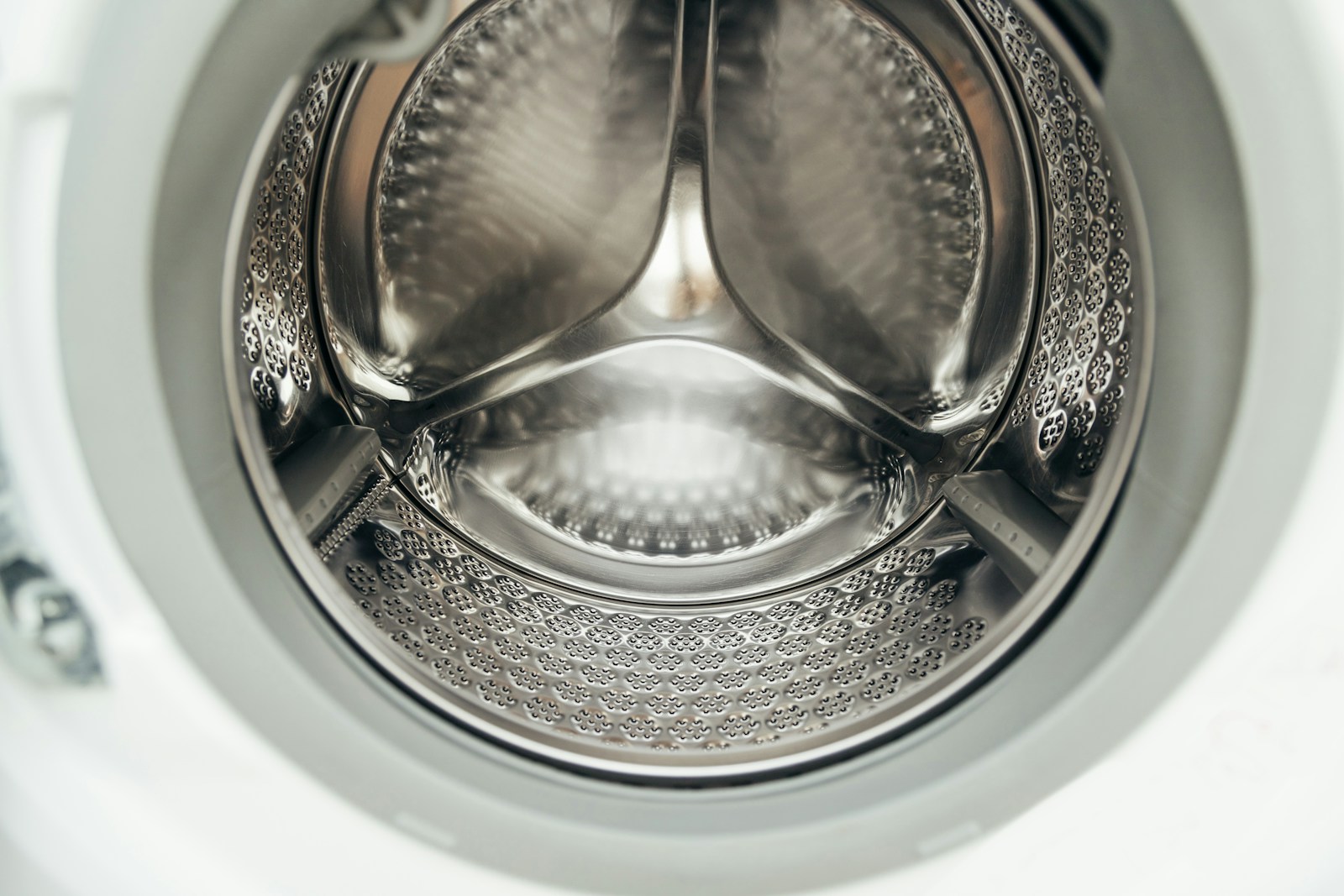 Inside view of a clean stainless-steel washing machine drum