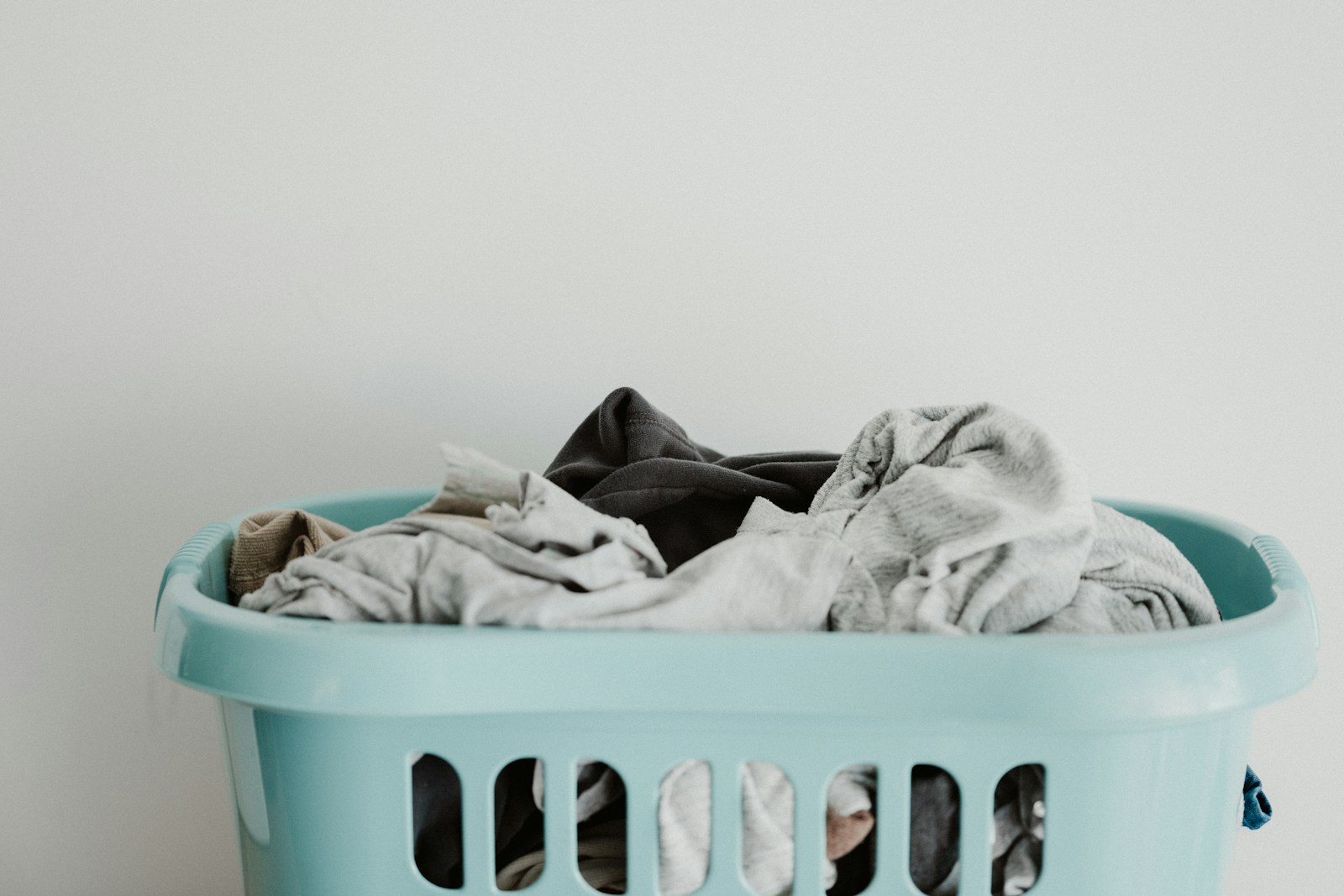 Freshly washed white laundry in a blue plastic basket