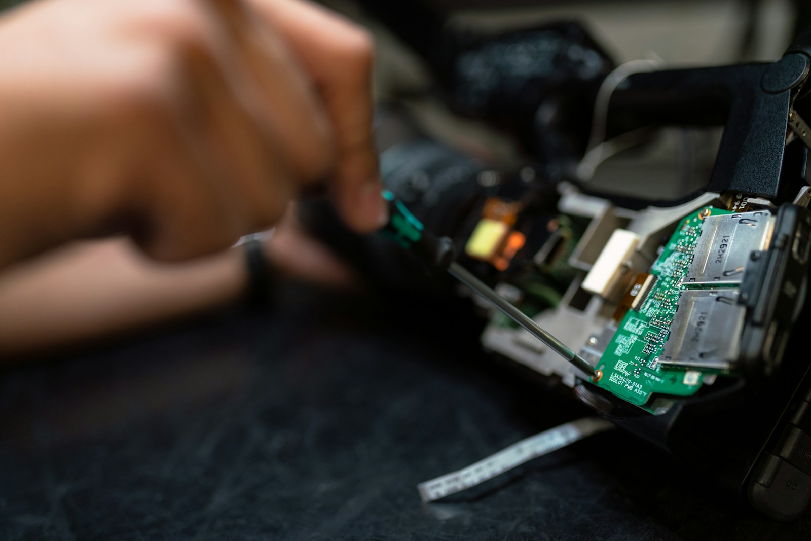 Technician holding a printed circuit board during electronic repair